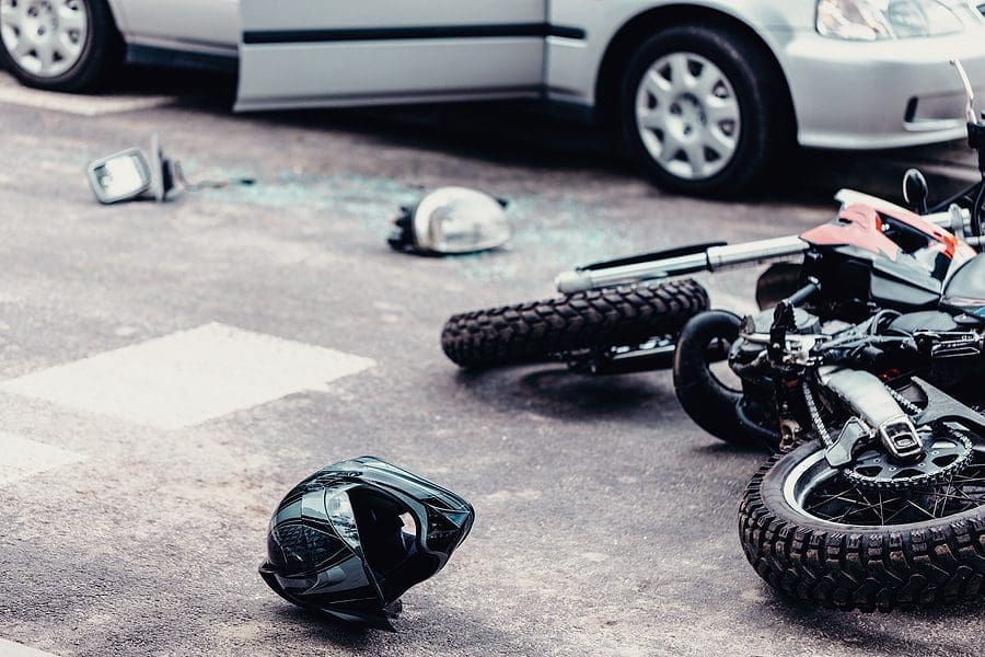 An Accident of a bike with a car. the bike is damaged a lot