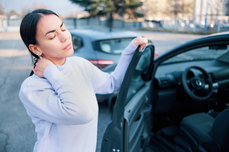 Woman holding her neck in pain after a minor car accident