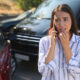 Woman talking on the phone at the the scene of a car accident looking stressed