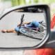 Bicyclist lying injured in the road after a bicycle accident with a car