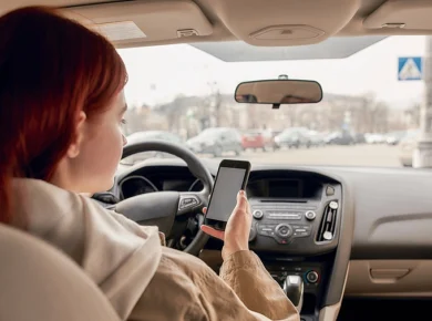Female distracted driver texting about to cause a pedestrian accident