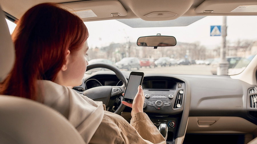 Female distracted driver texting about to cause a pedestrian accident