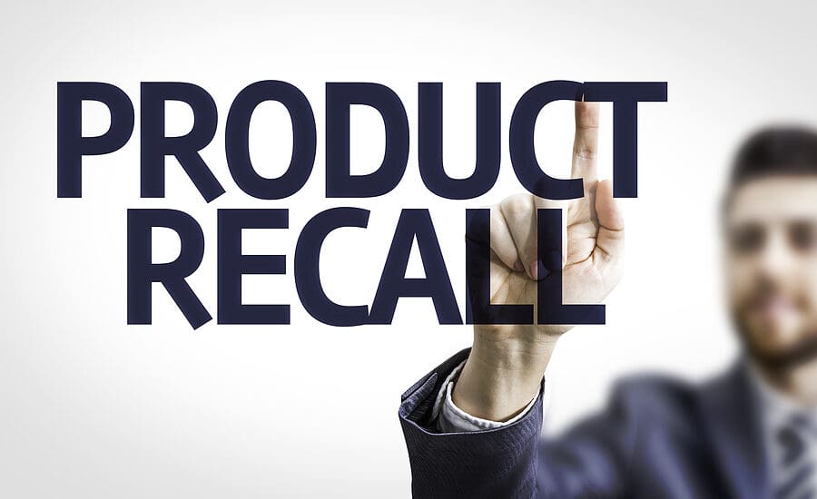 Business man pointing to transparent board with text: Product Recall