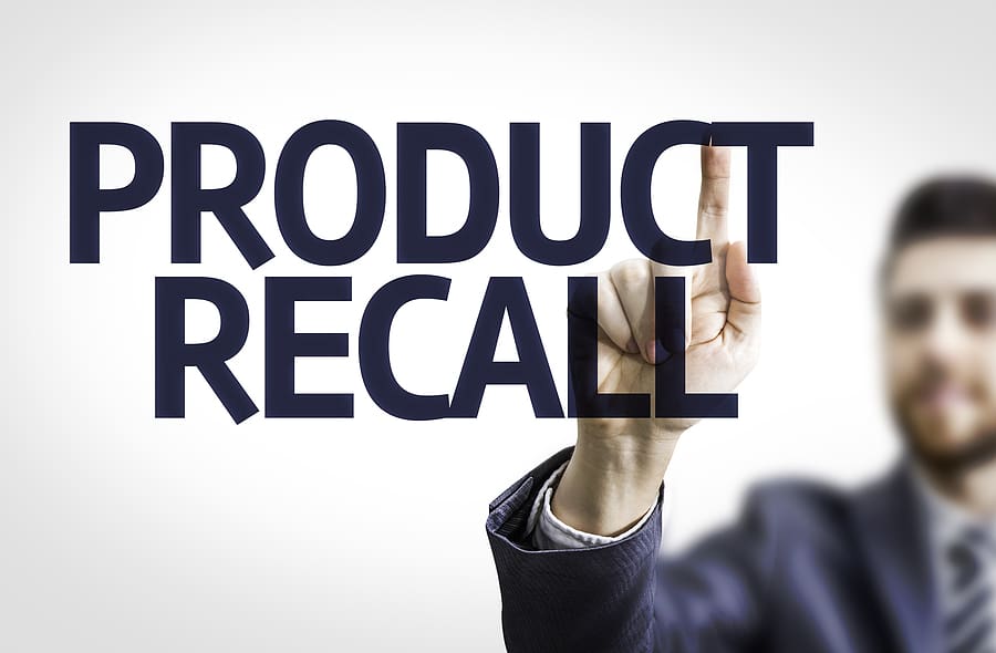 Business man pointing to transparent board with text: Product Recall