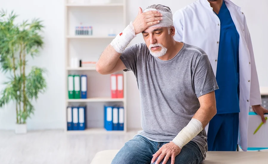 Accident victim with multiple traumatic injuries to his head and arms at the doctor