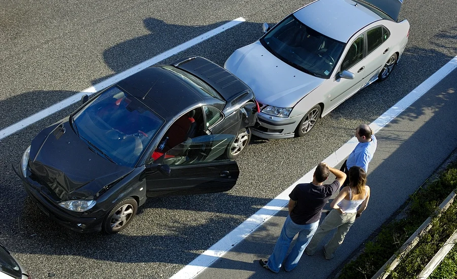 Group of people at the scene of a minor fender bender discussing if they should report it