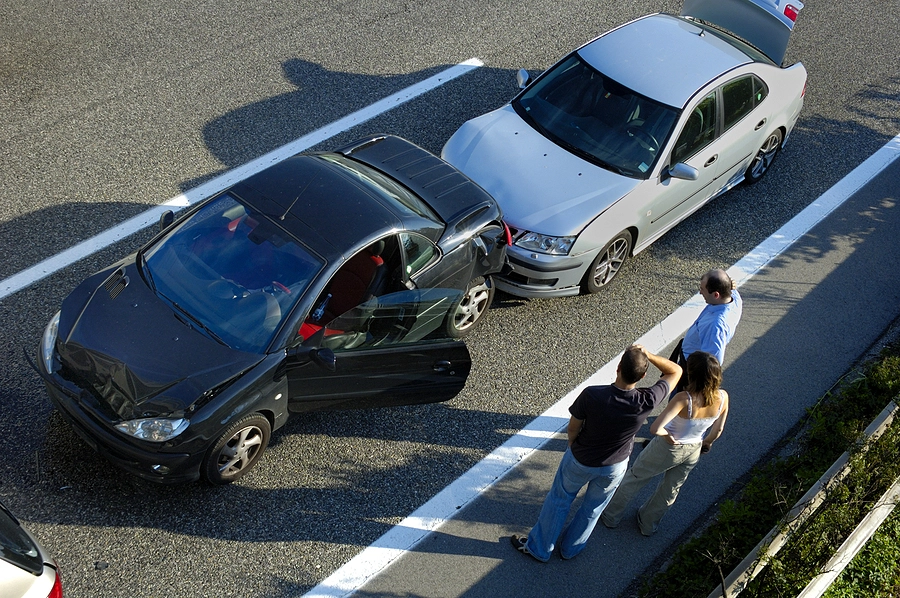 Group of people at the scene of a minor fender bender discussing if they should report it