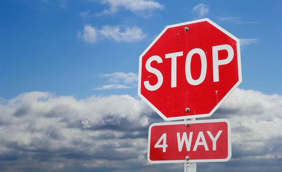 Picture of a 4-way-stop sign where drivers have to obey the rules about who goes first