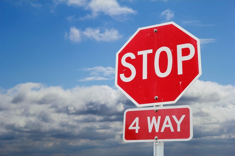 Picture of a 4-way-stop sign where drivers have to obey the rules about who goes first