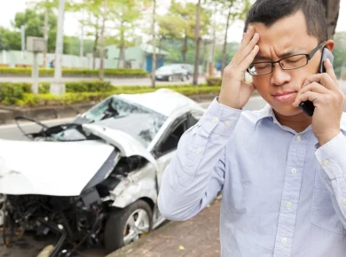 man making a call to his insurance company after a car accident