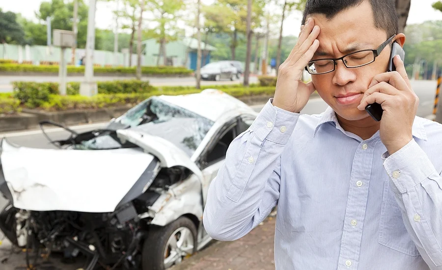 man making a call to his insurance company after a car accident