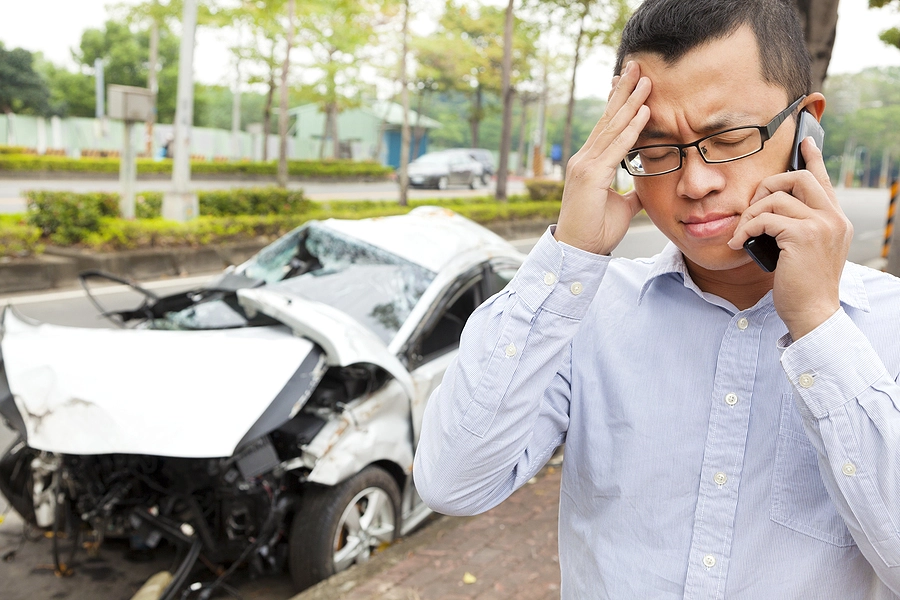 man making a call to his insurance company after a car accident