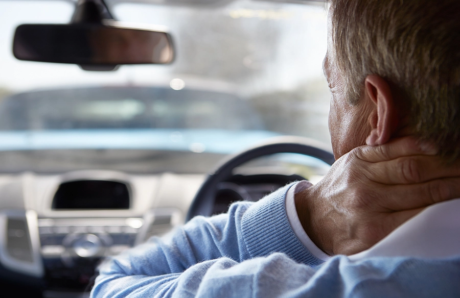 driver with whiplash holding his neck after a lakewood estates car accident