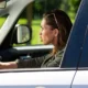 female driver engages in an example of risk while driving by honking her horn and tailgating