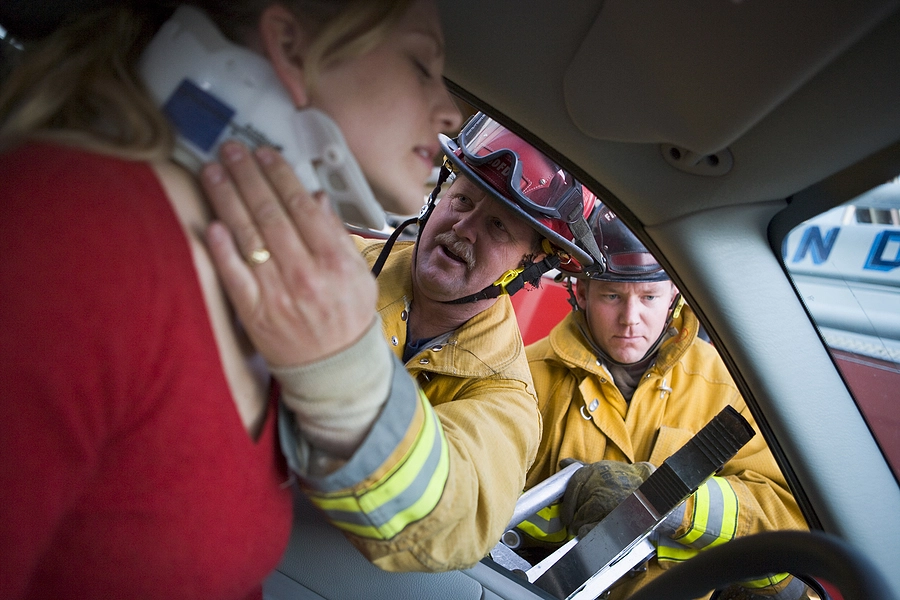 firefighters put a neck brace on an injured female driver after an edgemoor car accident