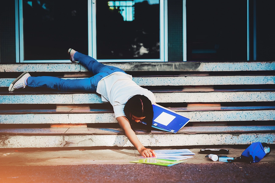 young asian female student falls down broken steps and drops her belongings in a gulfport slip and fall accident