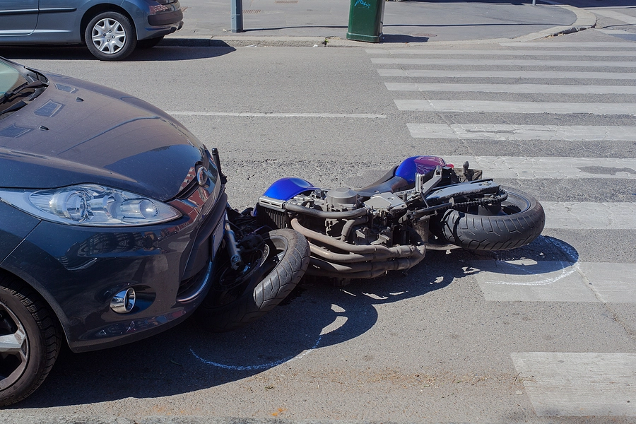 motorcycle crushed by car in the street